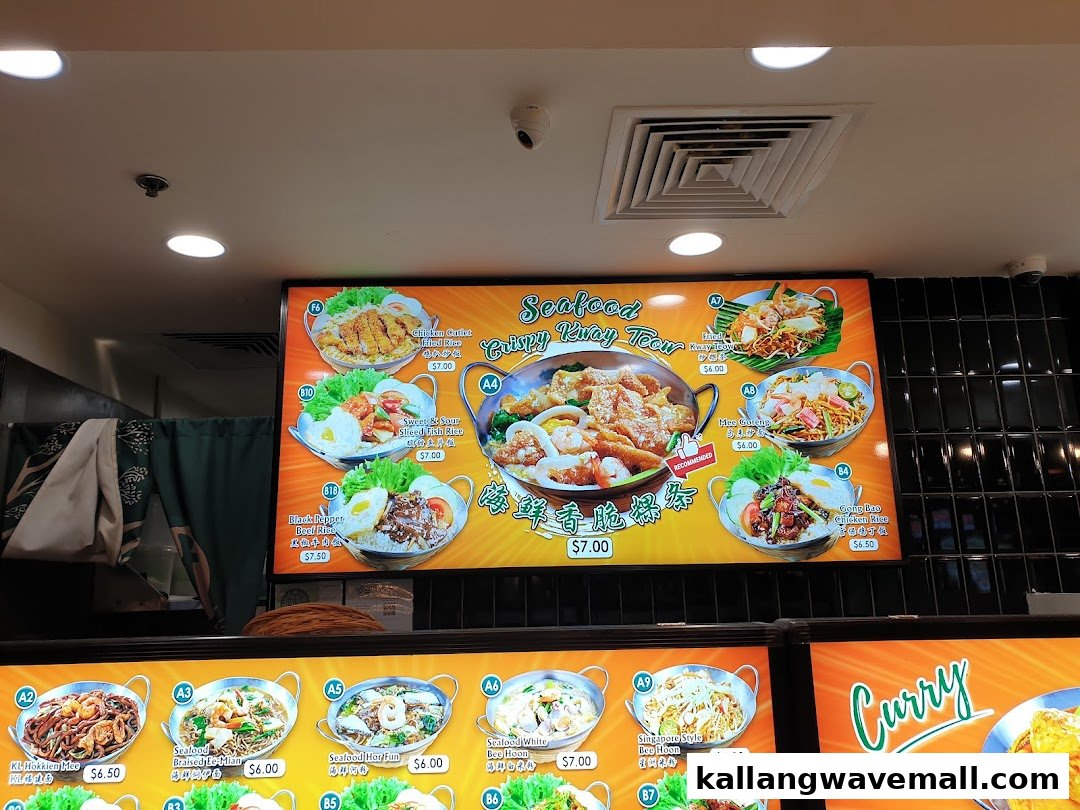 A digital menu board displaying various Asian noodle and rice dishes with prices at My Kampung.