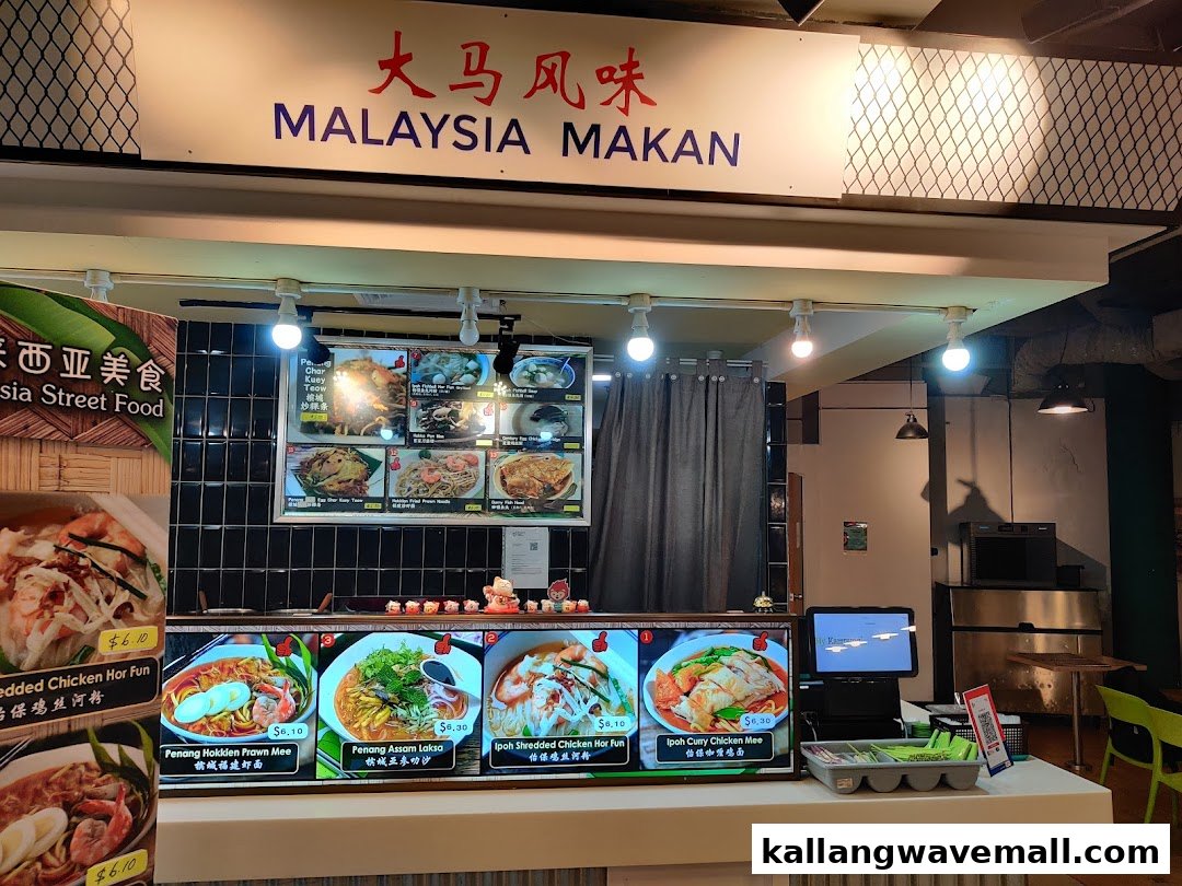A vibrant food stall named 'Malaysia Makan' showcasing various Malaysian street food dishes on display boards.