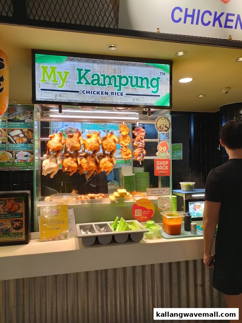 A vibrant chicken rice stall, 'My Kampung', showcasing roasted chickens and a welcoming counter.