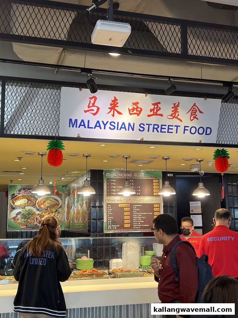 Customers ordering at My Kampung, a Malaysian street food stall, with menu boards visible.