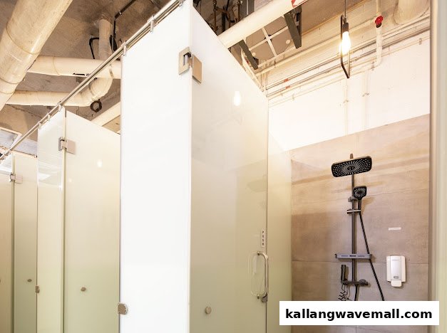 Modern shower facilities with multiple frosted glass stalls and a sleek shower head.
