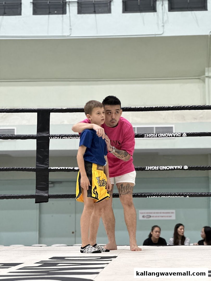 An instructor guides a young student in a boxing ring, demonstrating focus and training.