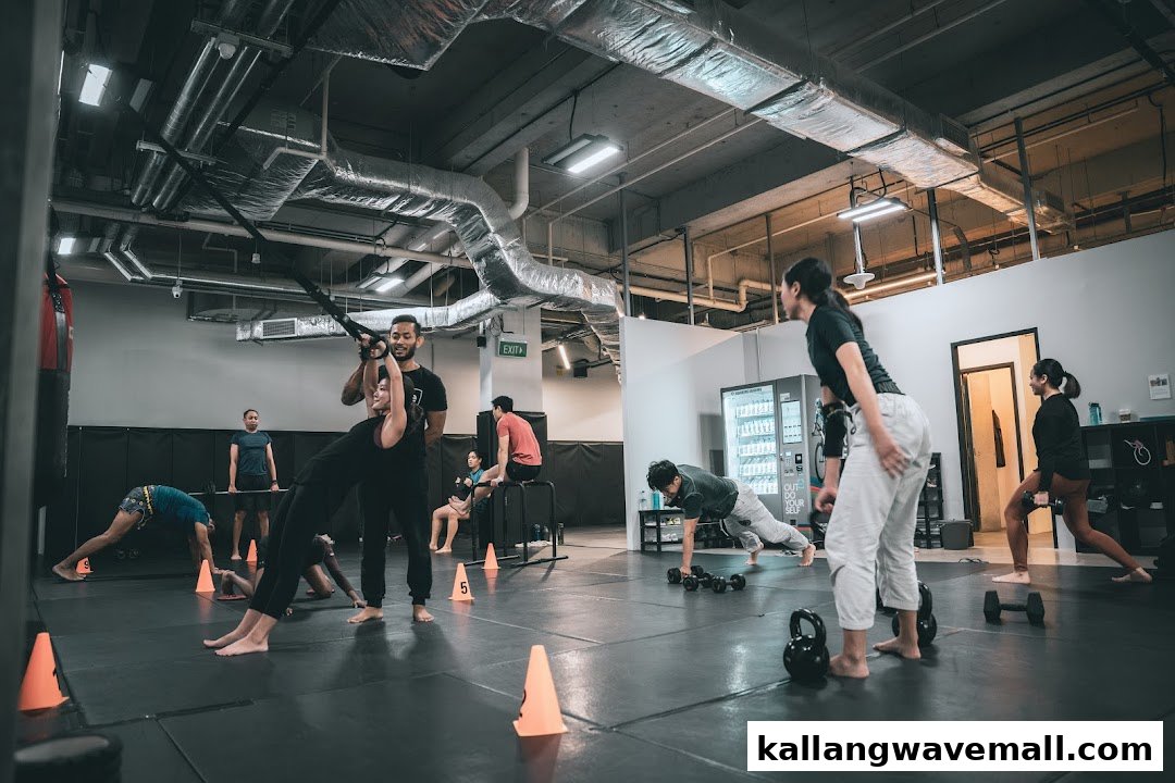 People engage in various exercises with trainers and equipment in a modern fitness studio.