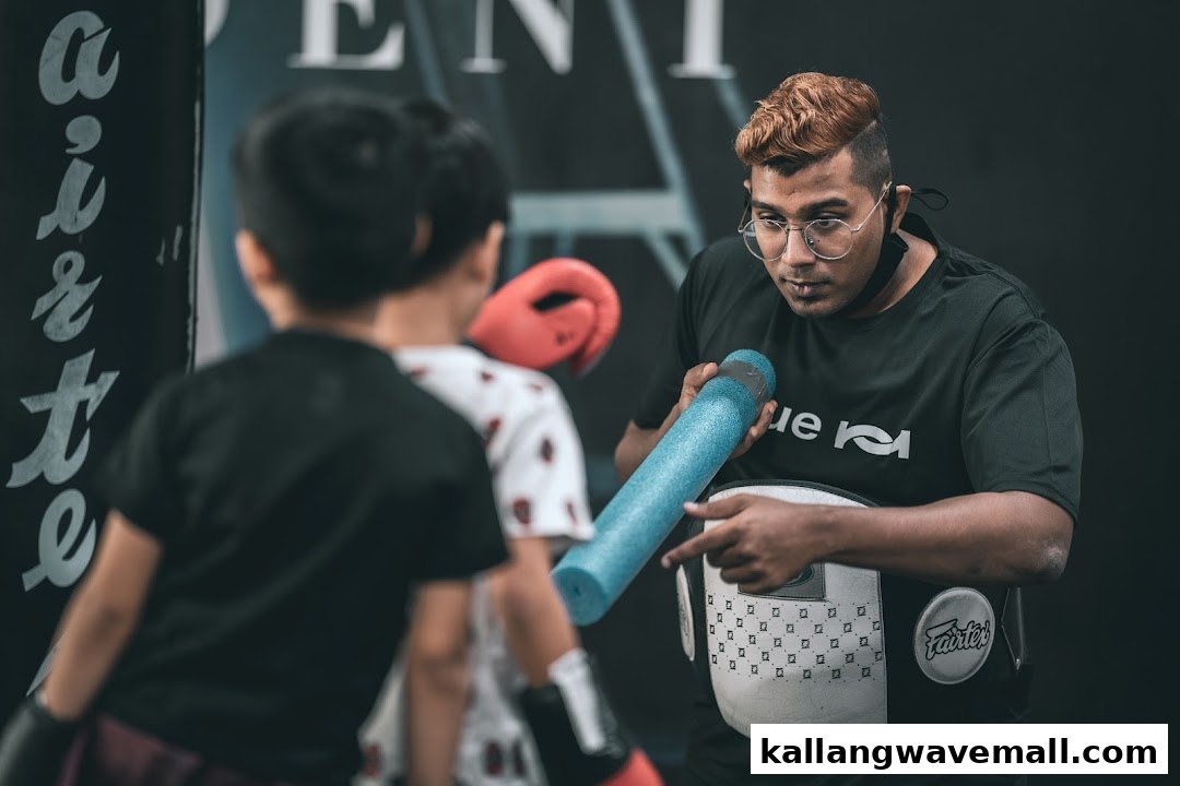 An instructor guides a young student during a martial arts training session at Neue Fit.