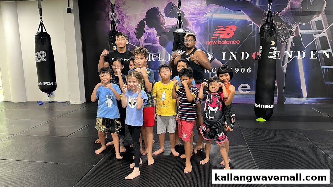 Adults and children pose in a martial arts gym with punching bags and New Balance branding.