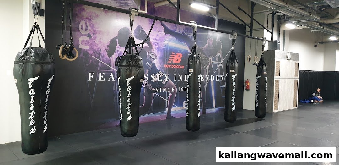 Interior view of a fitness gym featuring multiple punching bags and a large wall graphic.