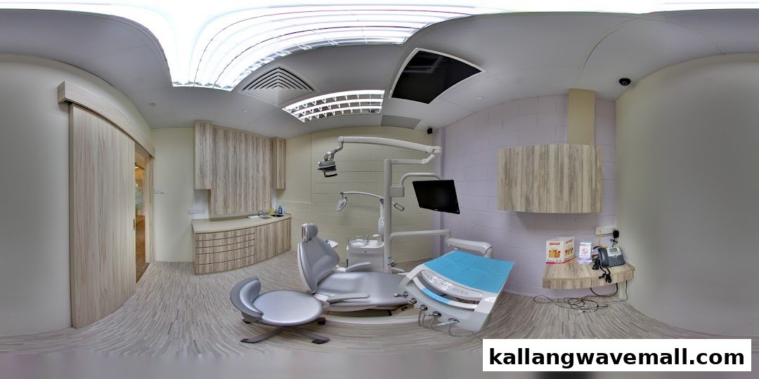 A modern dental treatment room with a patient chair, dental equipment, and cabinetry.