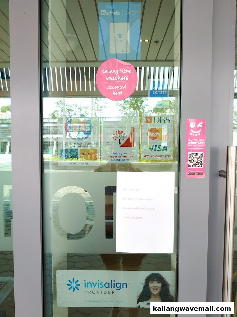 Glass entrance door of Newport Dental, showing accepted payments, health schemes, and Invisalign provider details.