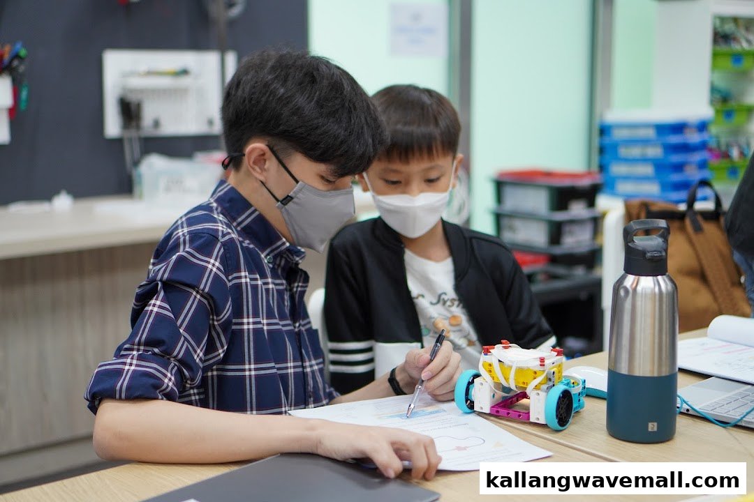 Two masked individuals, an instructor and a child, engaged in a hands-on robotics activity.