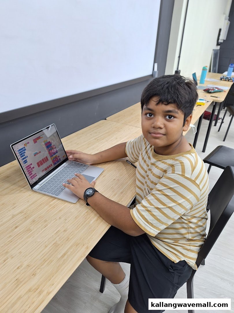 A young student actively engaged in coding on a laptop at Nullspace Robotics.