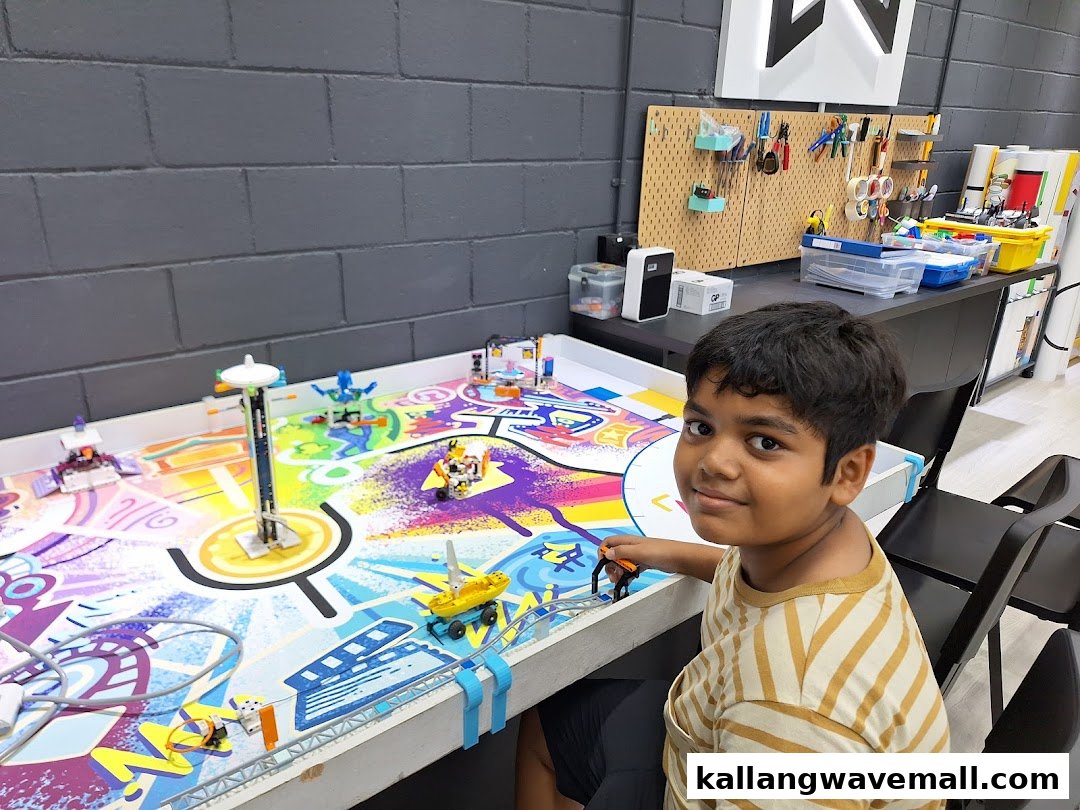 A child smiles while engaging with a colorful robotics and coding setup at Nullspace Robotics.