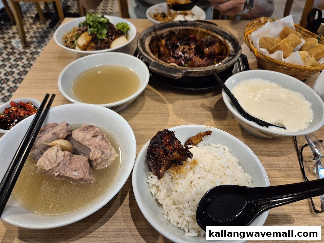 A table laden with various delicious dishes, including Bak Kut Teh, rice, and side dishes.
