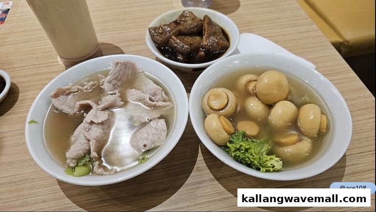Two bowls of soup, one with pork and one with mushrooms, with a side dish and drink.