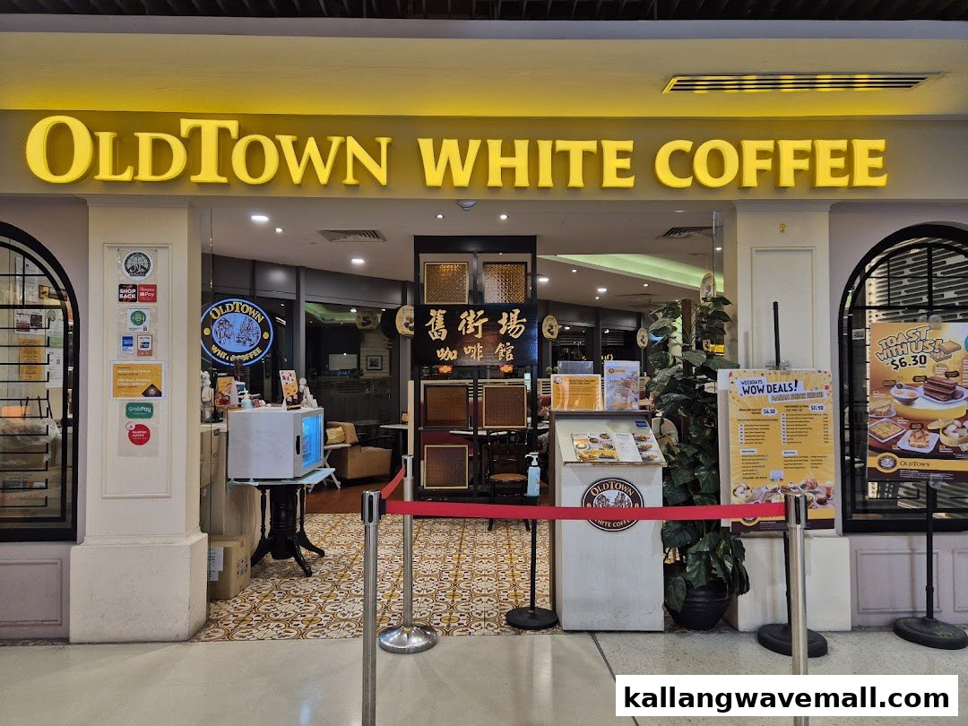 The brightly lit entrance of Oldtown White Coffee, showcasing its inviting facade and promotional displays.