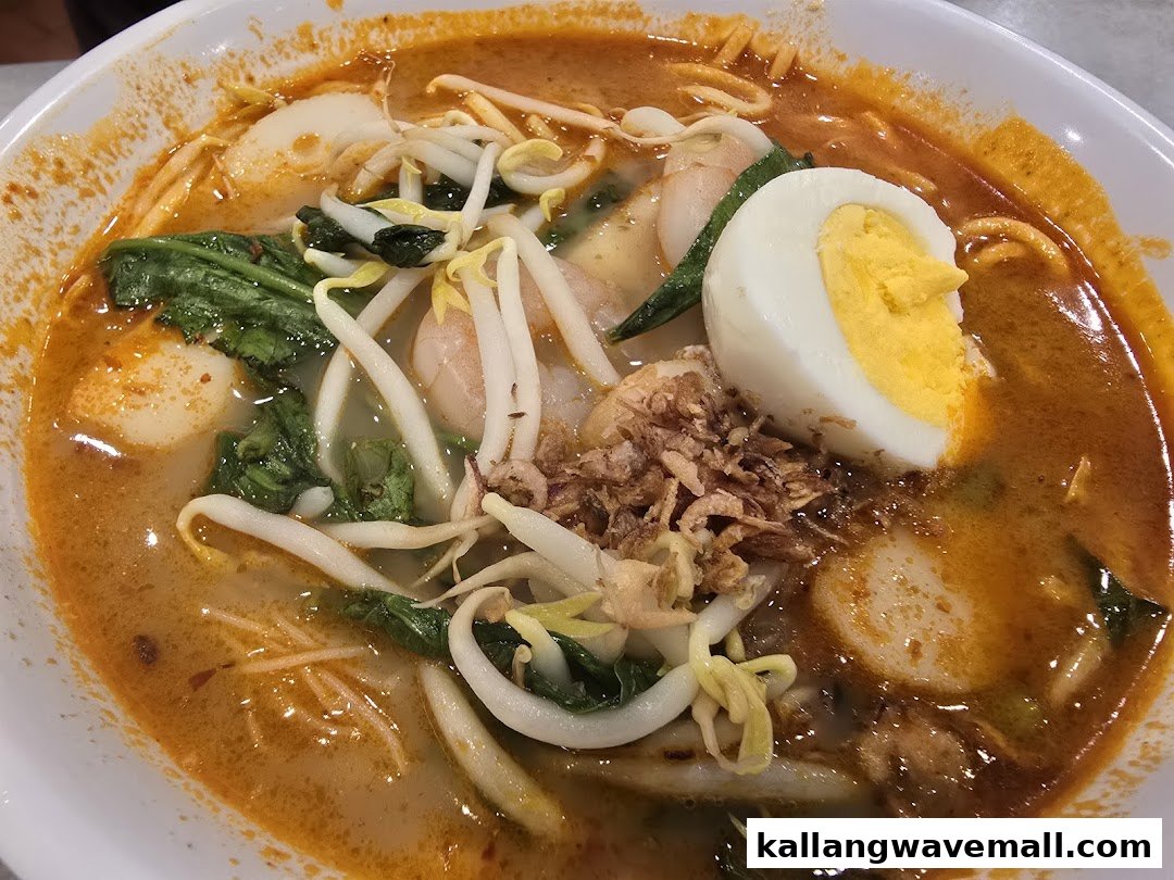A vibrant bowl of spicy noodles with prawns, bean sprouts, greens, and a hard-boiled egg.
