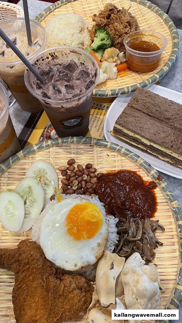 A table laden with traditional Malaysian dishes like Nasi Lemak, other rice meals, and iced beverages.