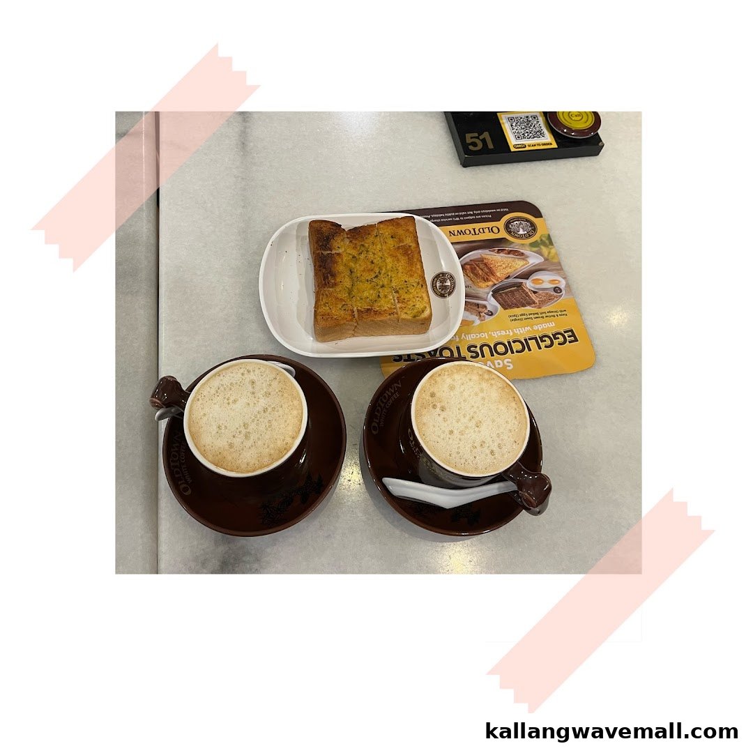 Two cups of coffee and a piece of toast on a table at Oldtown White Coffee.