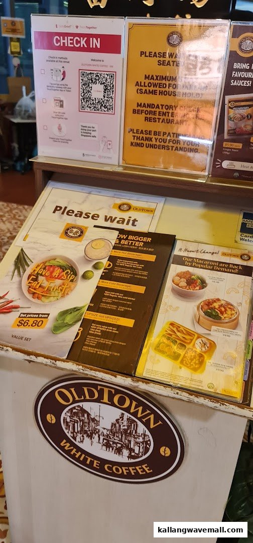 Various informational and promotional displays at the entrance of Oldtown White Coffee.