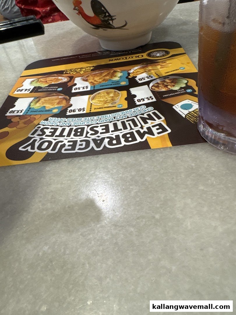 A menu placemat from Oldtown White Coffee featuring 'Lite Bites' with prices, alongside a bowl and drink.