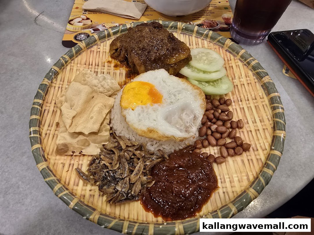 A traditional Nasi Lemak dish with chicken, fried egg, and condiments on a woven tray.