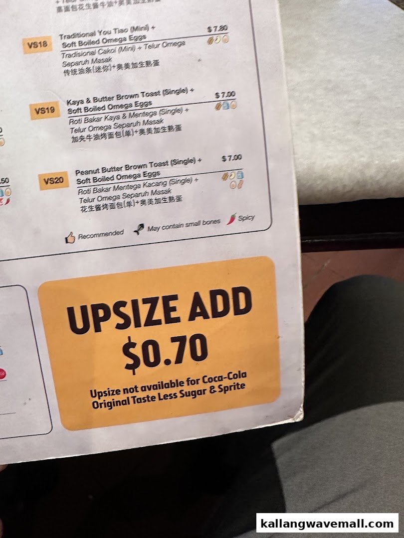 A close-up of Oldtown White Coffee's menu, featuring breakfast sets and an upsizing option.
