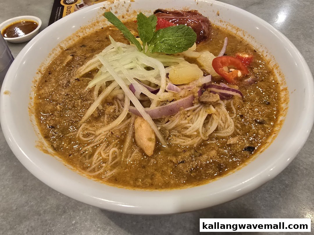 A close-up of a vibrant bowl of curry laksa or similar noodle dish with fresh toppings.