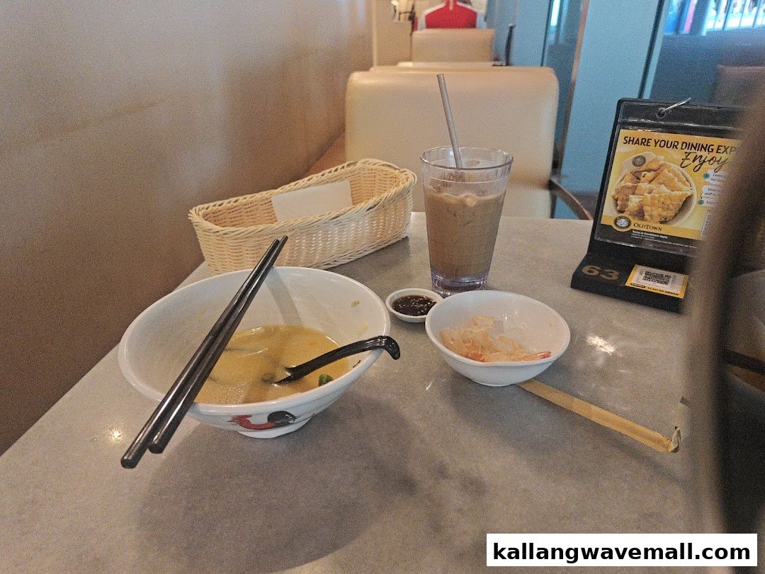 A table at Oldtown White Coffee with a partially eaten meal, drink, and table display.