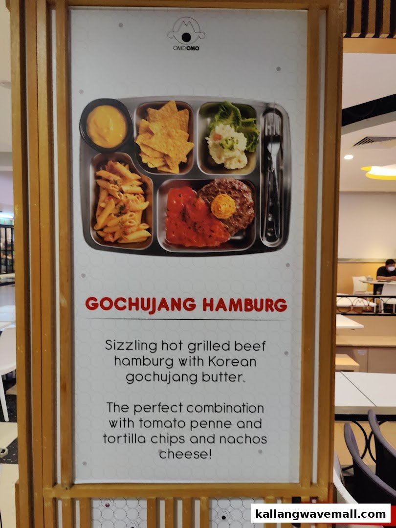 A promotional sign for OMOOMO featuring their Gochujang Hamburg meal with sides.