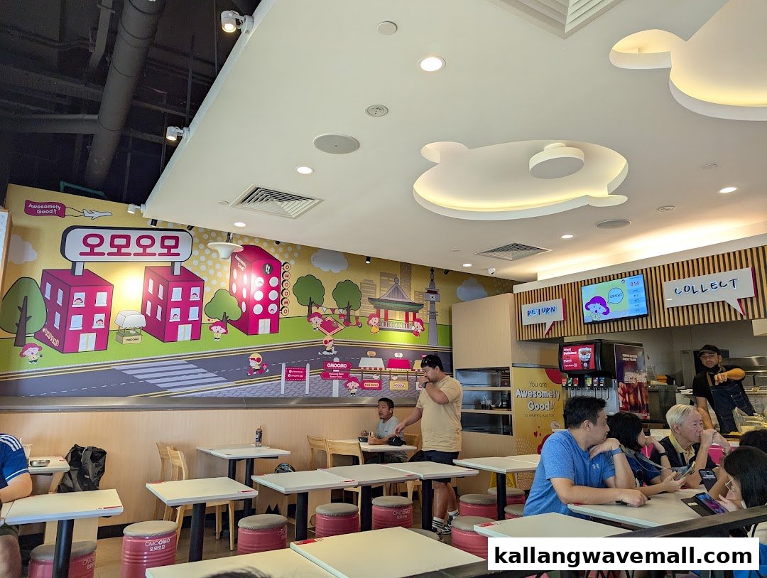 Interior view of OMOOMO restaurant with customers dining and a vibrant wall mural.