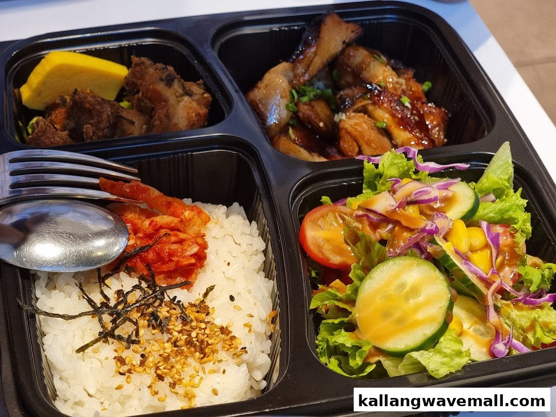 A delicious bento box featuring teriyaki chicken, rice, kimchi, salad, and side dishes.