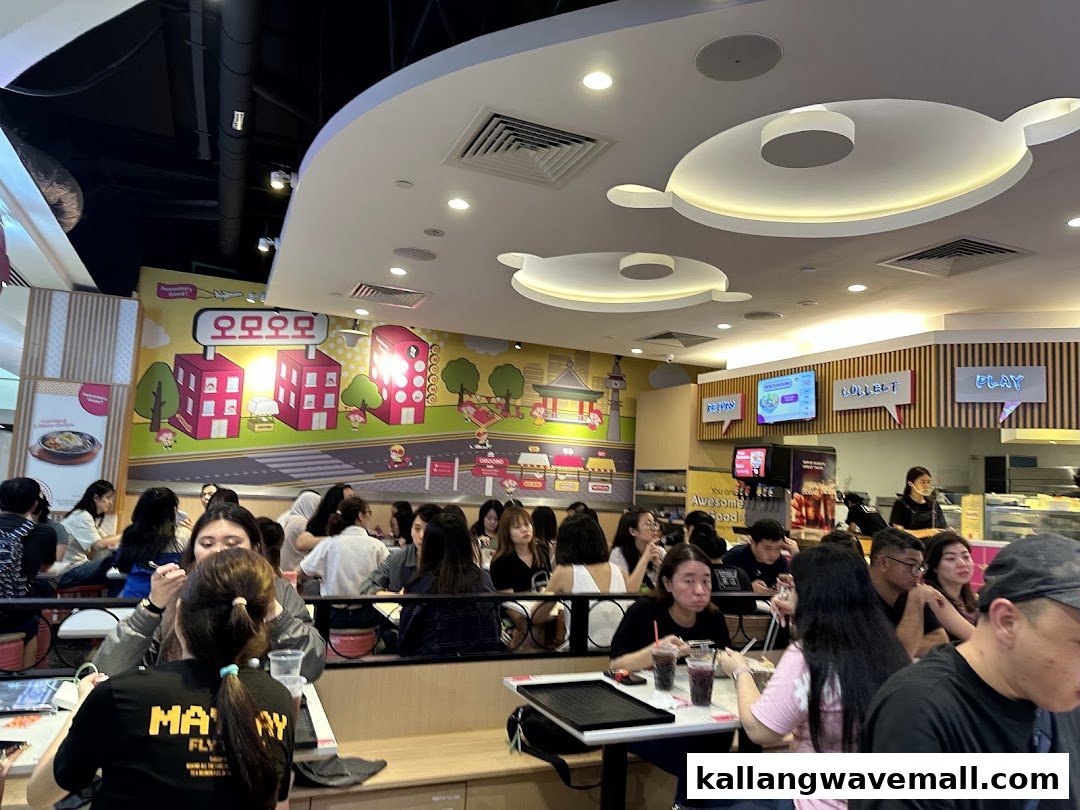 A bustling interior view of OMOOMO restaurant with customers dining amidst vibrant Korean-themed decor.