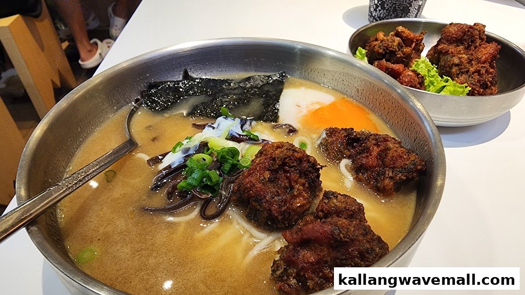A close-up of a delicious bowl of ramen with fried chicken and a side of crispy fried chicken.