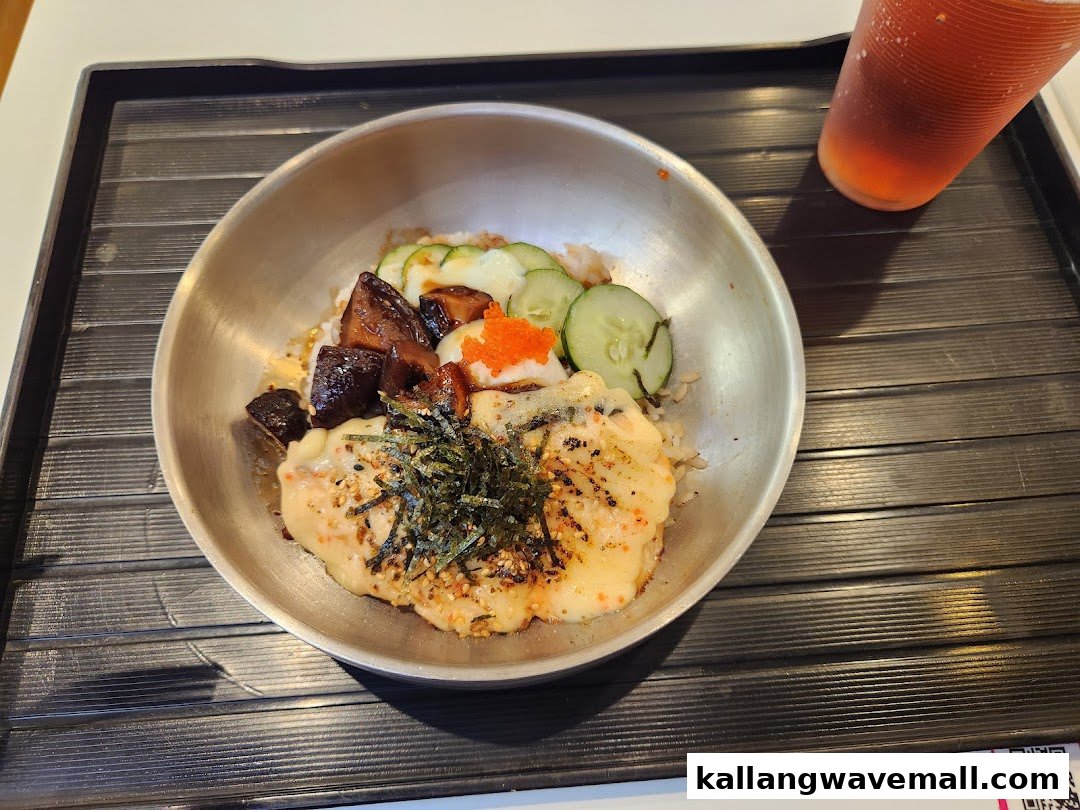 A delicious rice bowl with various toppings and a drink on a tray.