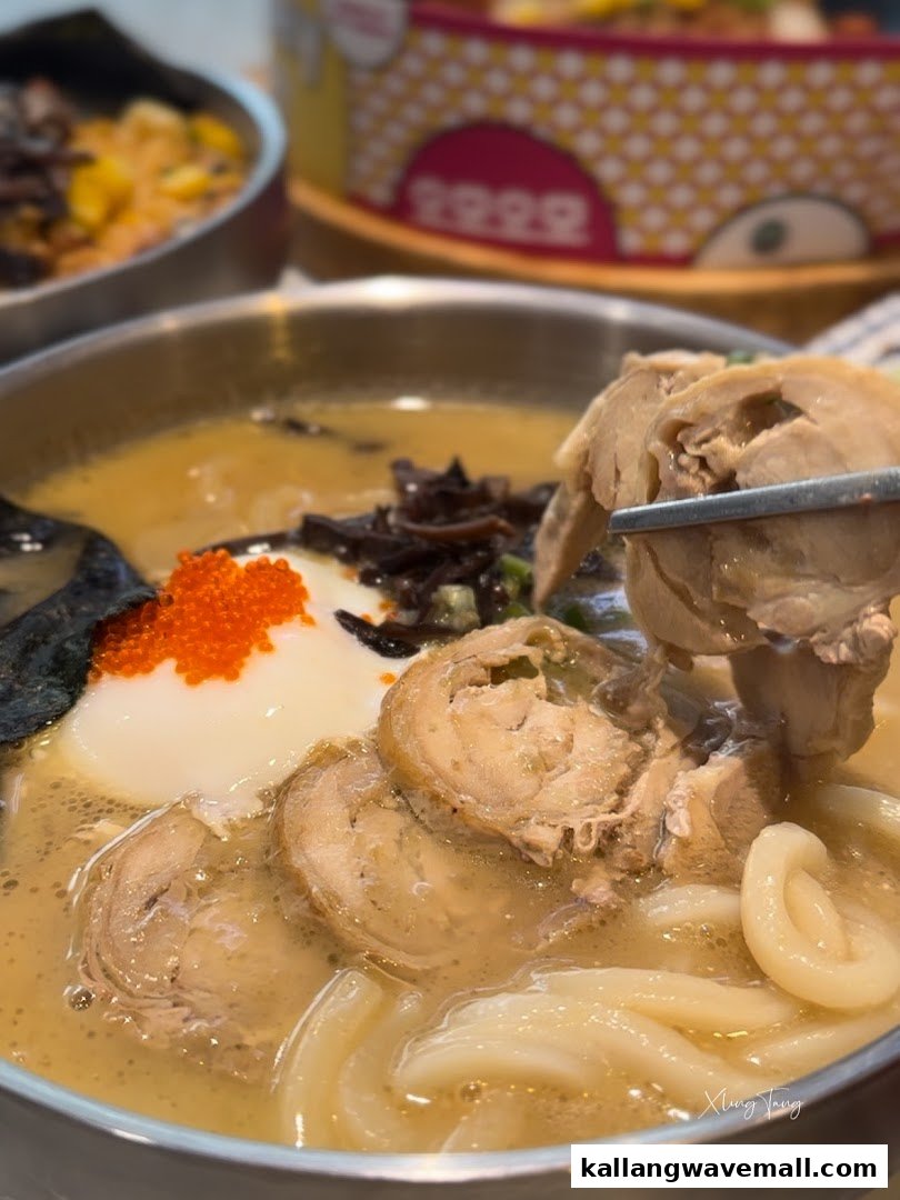 A close-up of a delicious bowl of ramen or udon with chicken, egg, and roe.