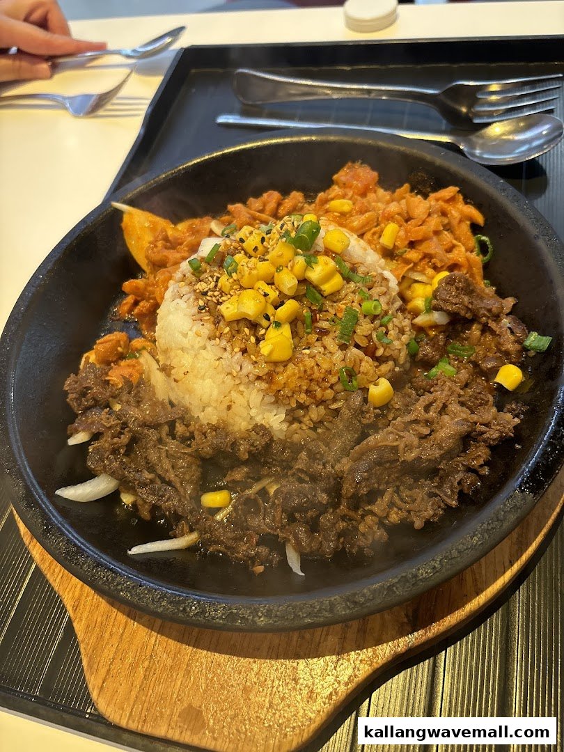 A sizzling hot plate dish with rice, beef, and kimchi, served at OMOOMO.