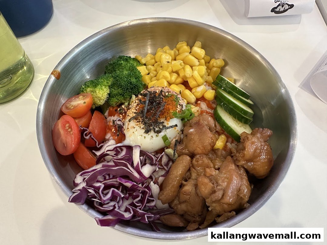 A vibrant, healthy bowl featuring chicken, vegetables, corn, and a poached egg.