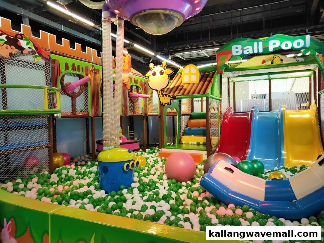 A vibrant indoor play area featuring a large ball pit, colorful slides, and multi-level play structures.