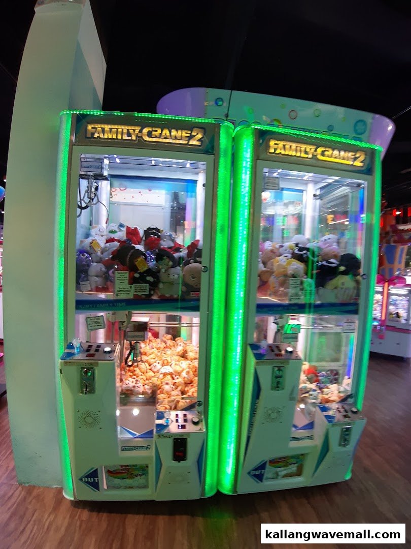 Two brightly lit 'Family Crane 2' arcade machines filled with plush toys inside an entertainment center.