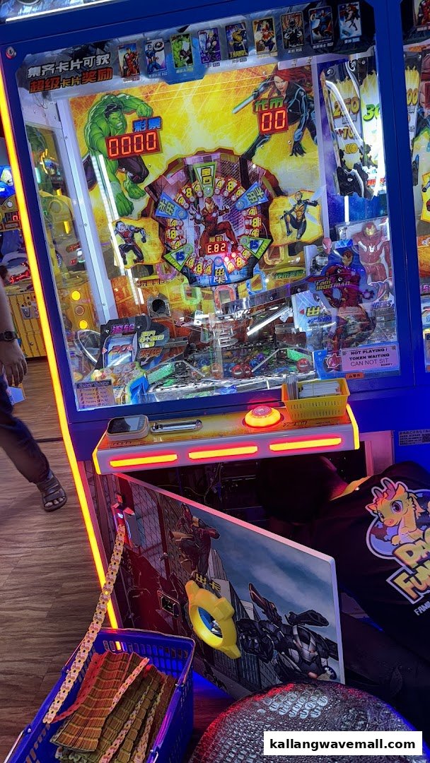 An arcade game machine featuring Marvel characters, dispensing tickets at Paco FunWorld.