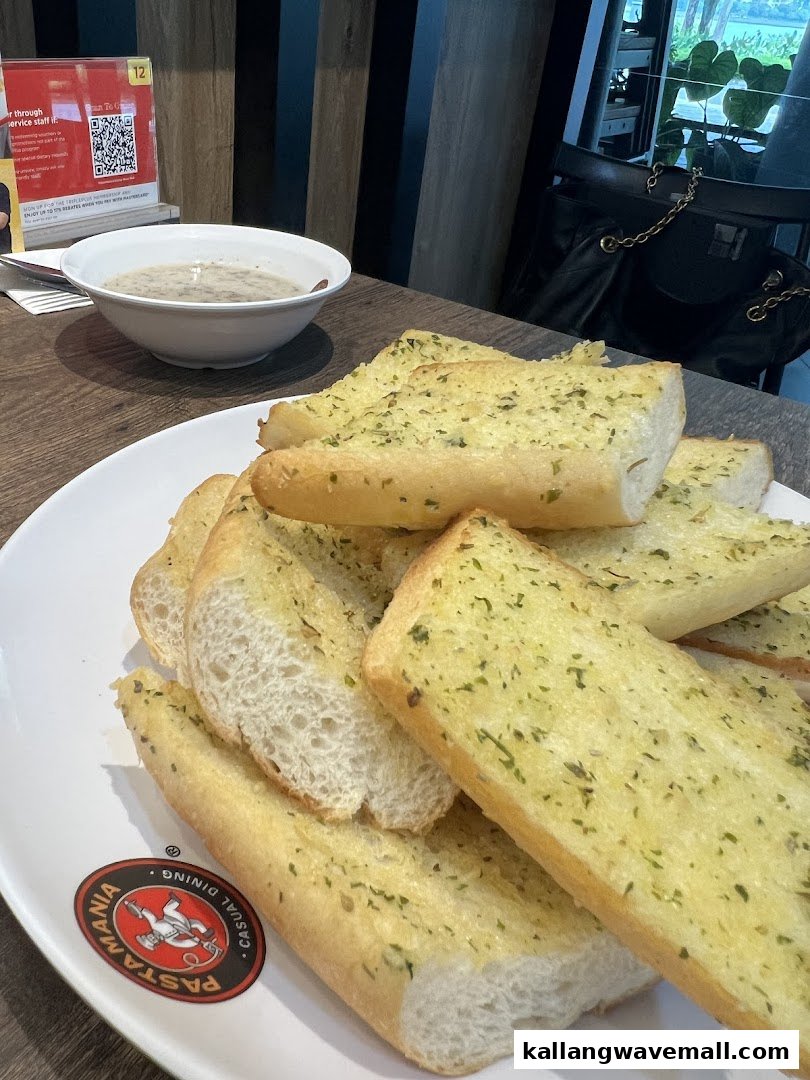 A close-up of delicious garlic bread and a bowl of soup on a table at PastaMania.