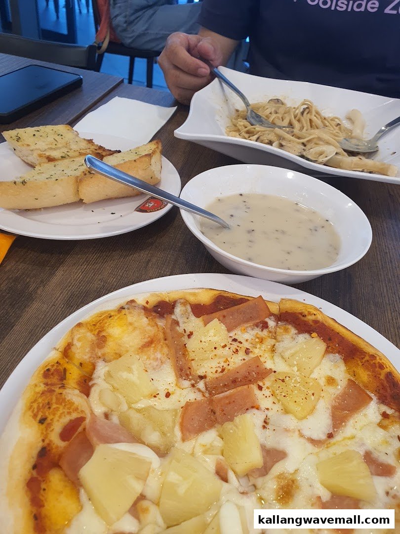 A table filled with various Italian dishes including pizza, pasta, soup, and garlic bread.