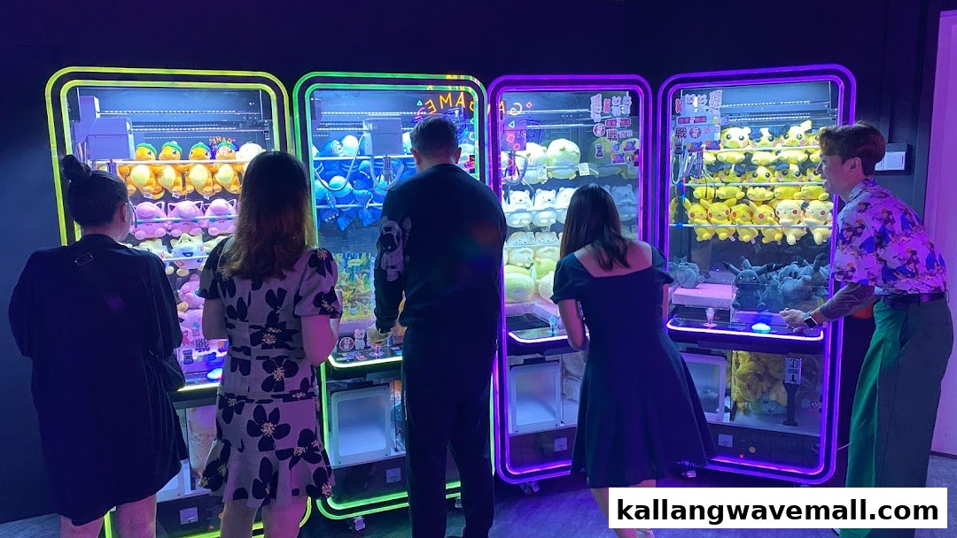 People are actively engaged in playing brightly lit claw machines filled with various plush toys.