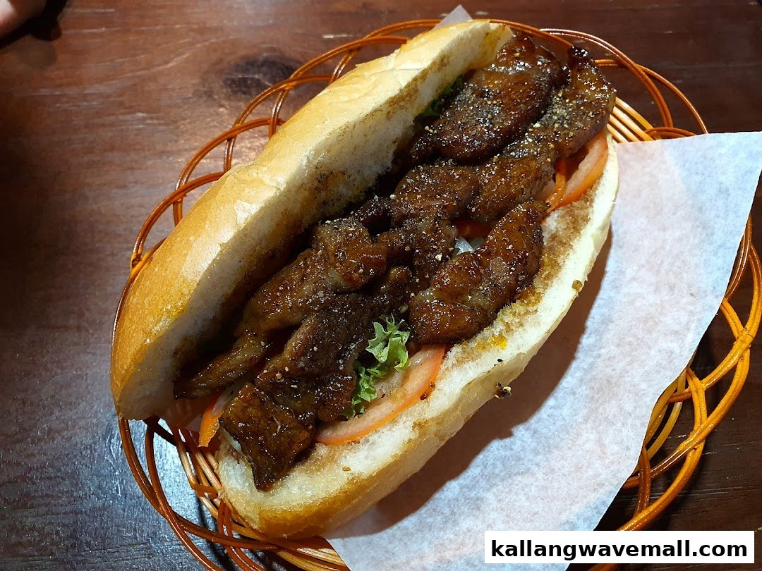 A close-up shot of a delicious-looking sandwich filled with grilled meat, lettuce, and tomatoes, served in a basket.