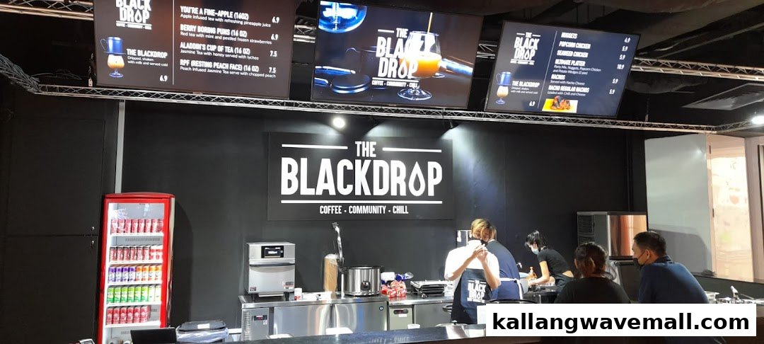 Digital menu boards displaying specialty drinks and snacks at The Blackdrop cafe.