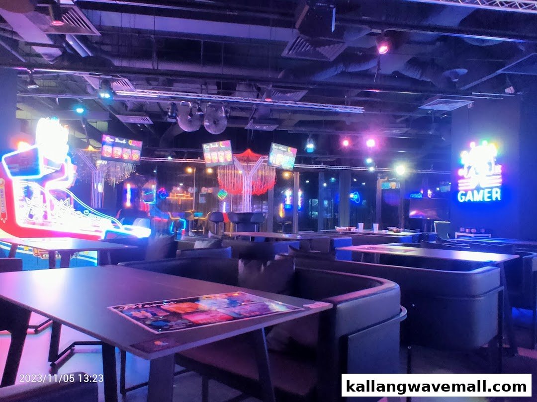 A vibrant interior shot of an entertainment venue with neon lights, arcade machines, and seating areas.