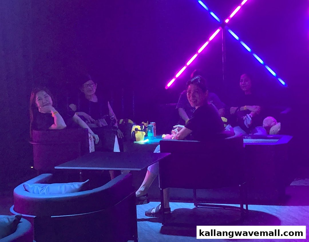 People relax in a vibrant, neon-lit entertainment space at PLAYKallang, enjoying the unique ambiance.