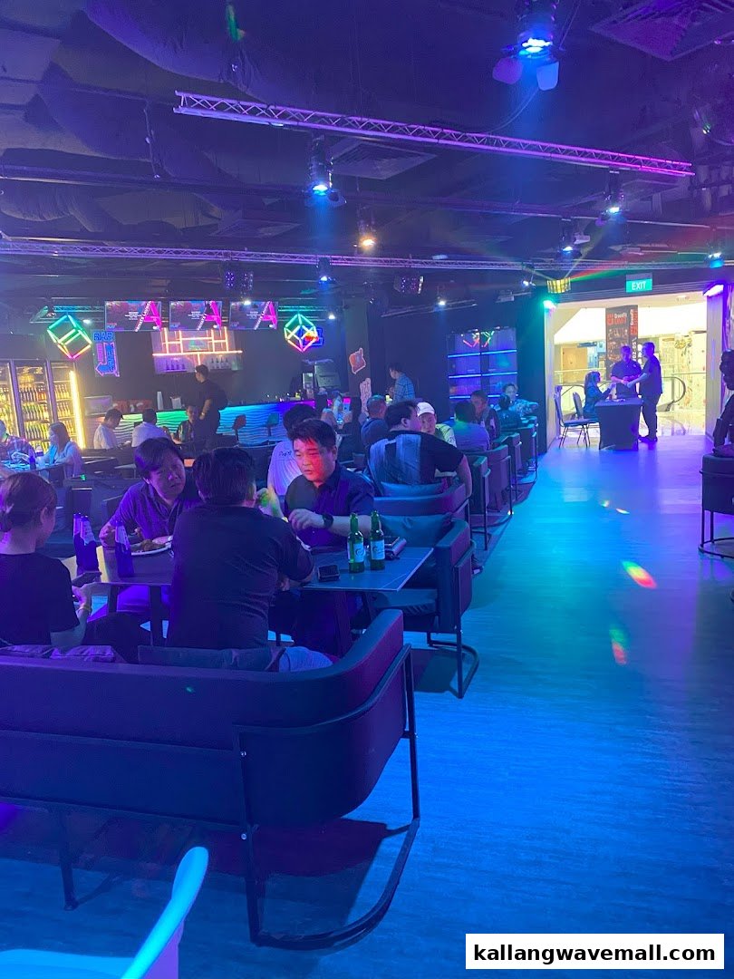 A vibrant interior shot of PLAYKallang, featuring patrons enjoying drinks and the lively atmosphere under neon lights.