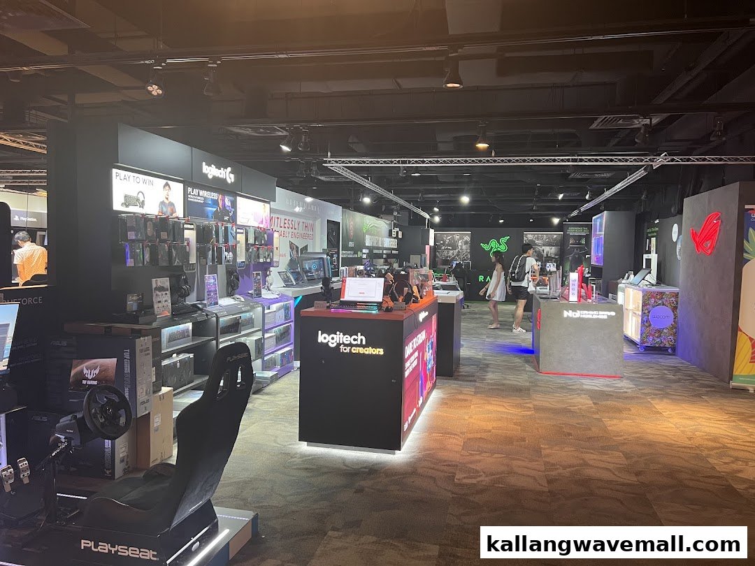 An interior view of a modern tech and gaming retail store featuring various brands and products.