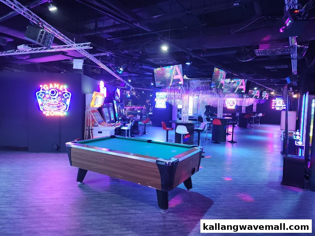 An indoor entertainment center featuring a pool table, arcade games, and vibrant neon lighting.