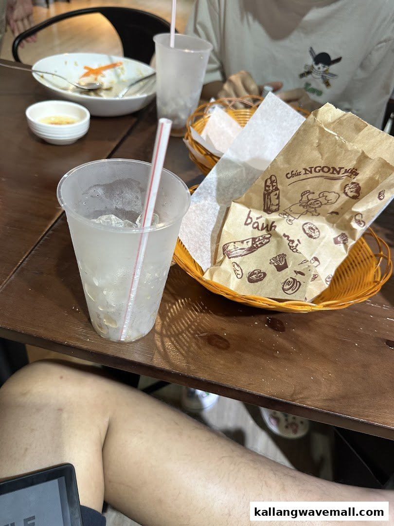 A table with drinks, a food basket, and a partially eaten meal, suggesting a casual dining experience.
